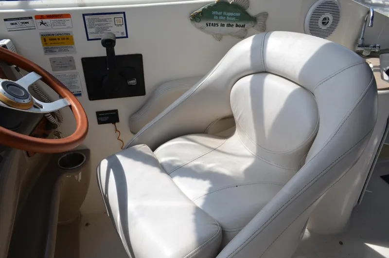 Slide: The Image of Captain's seat in 2006 Larson Cabrio 240 boat, featuring steering wheel and control panel. - 16