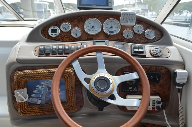 Slide: The Image of 2006 Larson Cabrio 240 dashboard with wood accents, gauges, and steering wheel. - 18
