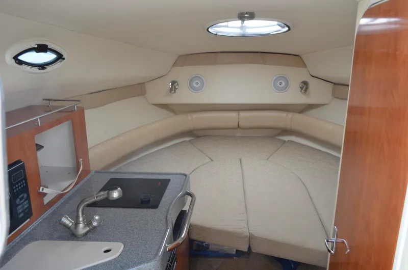 Slide: The Image of Interior of a 2006 Larson Cabrio 240 boat with kitchenette and seating area. - 20