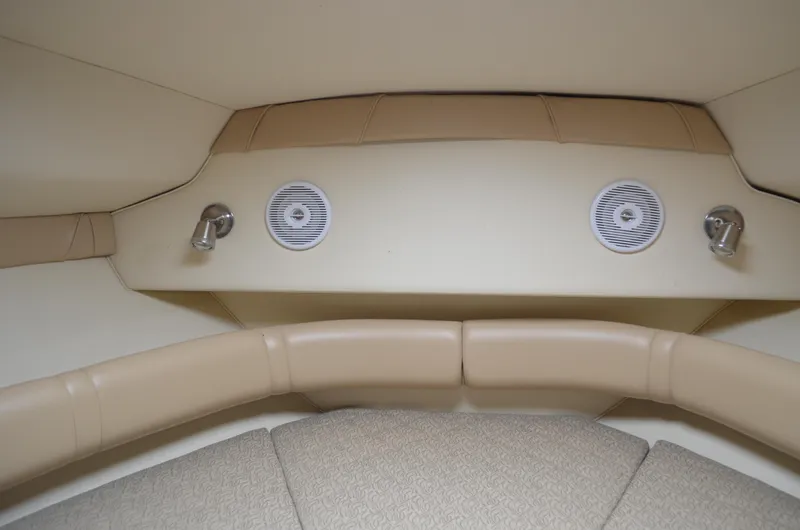 Slide: The Image of Interior of 2006 Larson Cabrio 240 boat with beige seating and built-in speakers. - 22