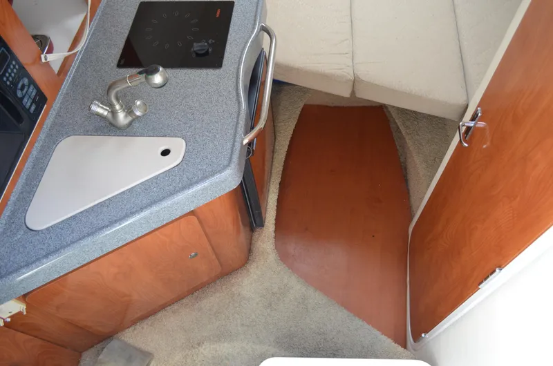 Slide: The Image of 2006 Larson Cabrio 240 interior with kitchenette and cozy sleeping area. - 24