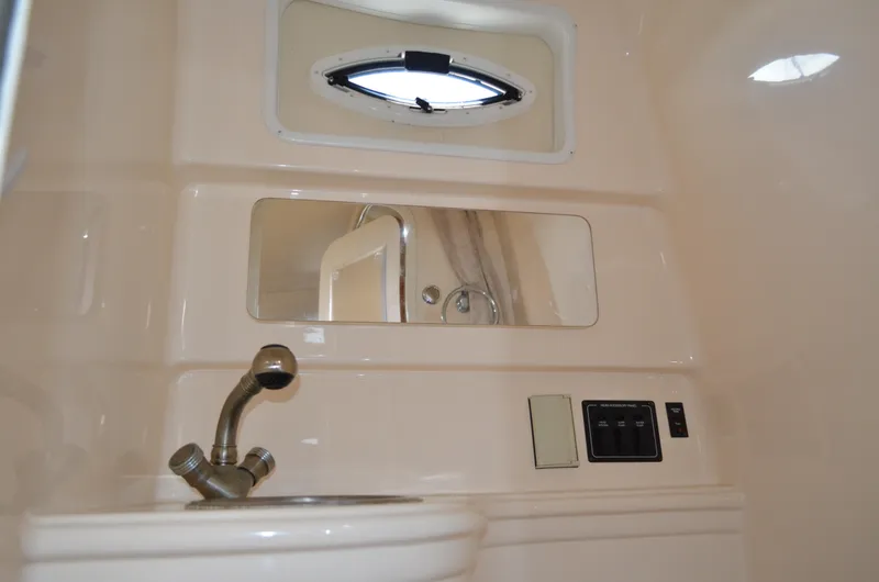 Slide: The Image of 2006 Larson Cabrio 240 boat interior with sink, mirror, and control panel. - 32