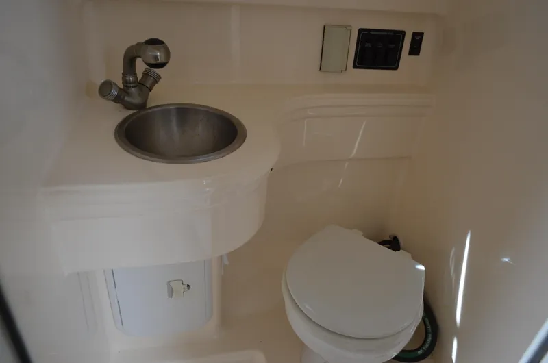 Slide: The Image of 2006 Larson Cabrio 240 boat bathroom with sink and toilet. - 33