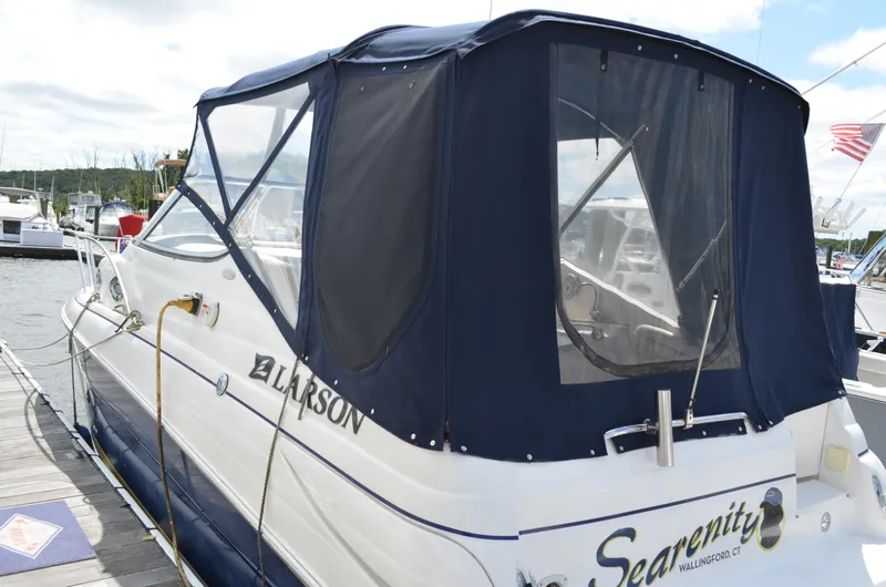 Slide: The Image of 2006 Larson Cabrio 240 boat docked with blue canopy and "Searenity" name visible. - 4