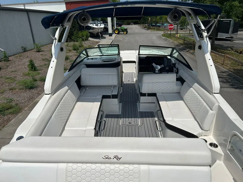 Slide: The Image of 2019 Sea Ray 270 SDX boat interior with white seating and blue canopy. - 12
