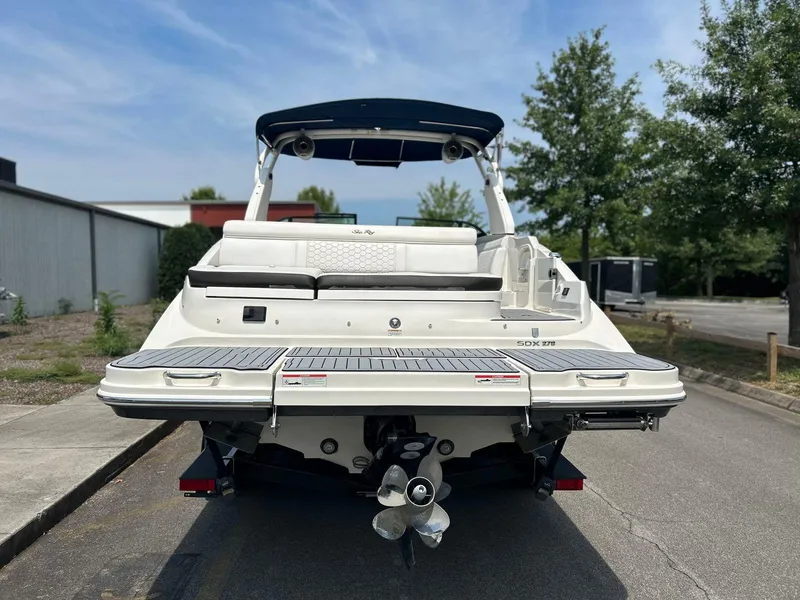 Slide: The Image of 2019 Sea Ray 270 SDX boat, rear view, parked on street with trees and buildings. - 15