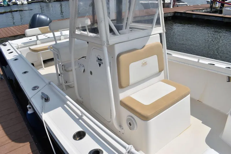 Slide: The Image of 2015 Steiger Craft 255 Center Console boat docked, featuring spacious seating and sleek design. - 13