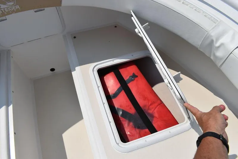 Slide: The Image of 2015 Steiger Craft 255 Center Console storage compartment with red life jacket. - 47