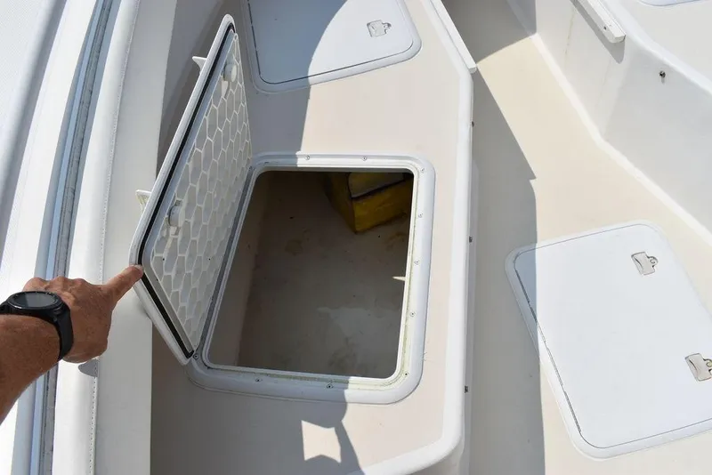 Slide: The Image of Open storage compartment on 2015 Steiger Craft 255 Center Console boat deck. - 49