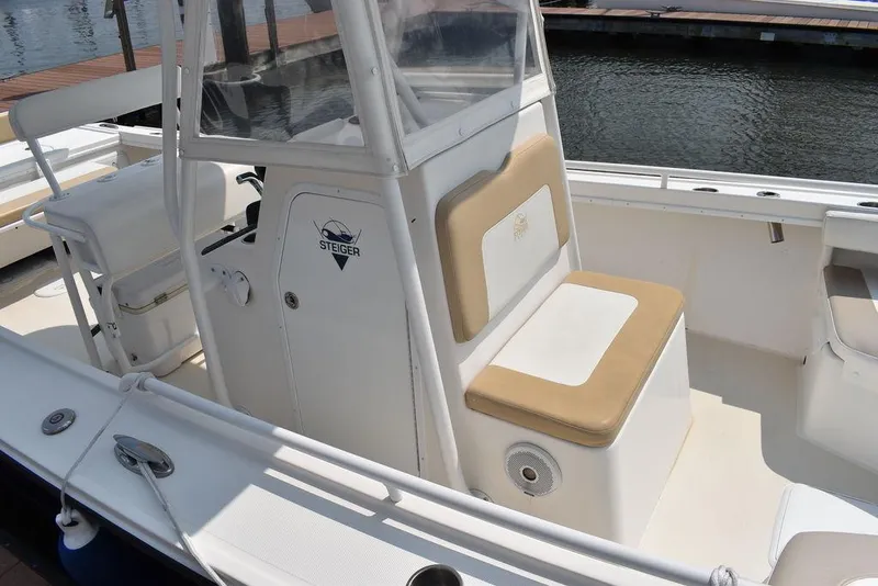 Slide: The Image of 2015 Steiger Craft 255 Center Console boat with beige seating, docked by the water. - 9