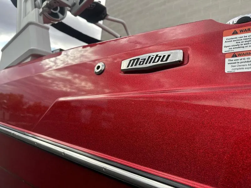Slide: The Image of 2021 Malibu M240 boat, red exterior, close-up view. - 11