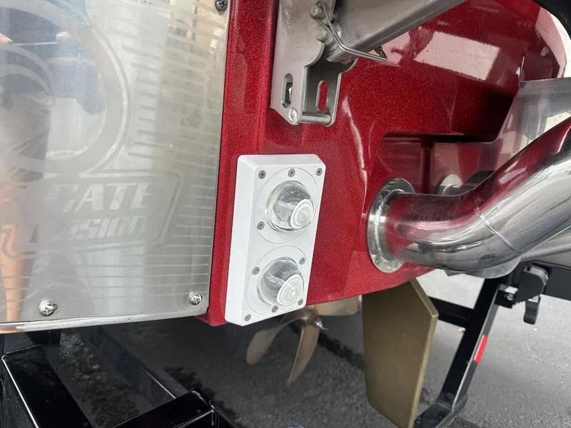 Slide: The Image of Close-up of 2021 Malibu M240 boat's rear detailing, showing exhaust and propeller components. - 13