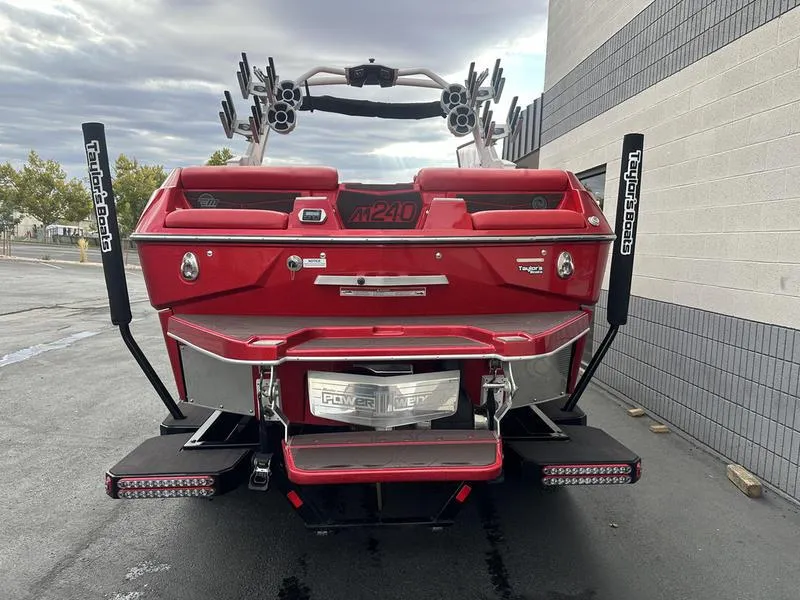 Slide: The Image of Red 2021 Malibu M240 boat rear view with wakeboard racks and Power Wedge III. - 15