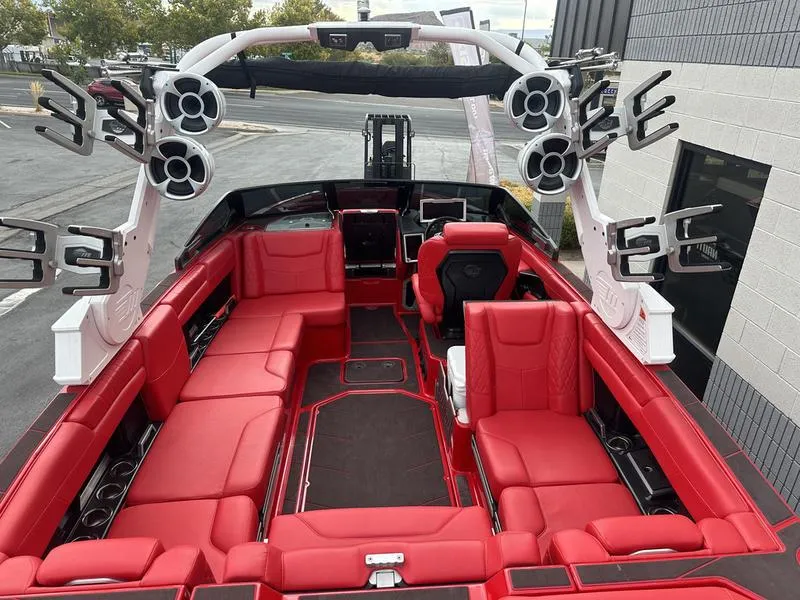 Slide: The Image of 2021 Malibu M240 boat with red interior and multiple speakers. - 17