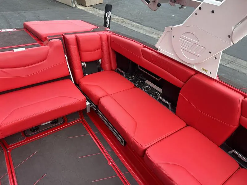 Slide: The Image of 2021 Malibu M240 boat interior with vibrant red seating and sleek design. - 20