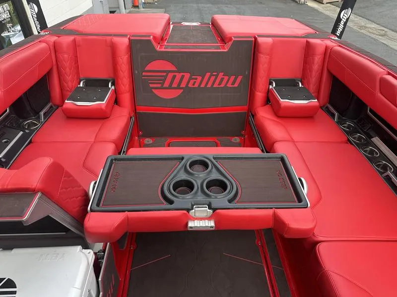 Slide: The Image of 2021 Malibu M240 boat interior with red seating and cup holders. - 22