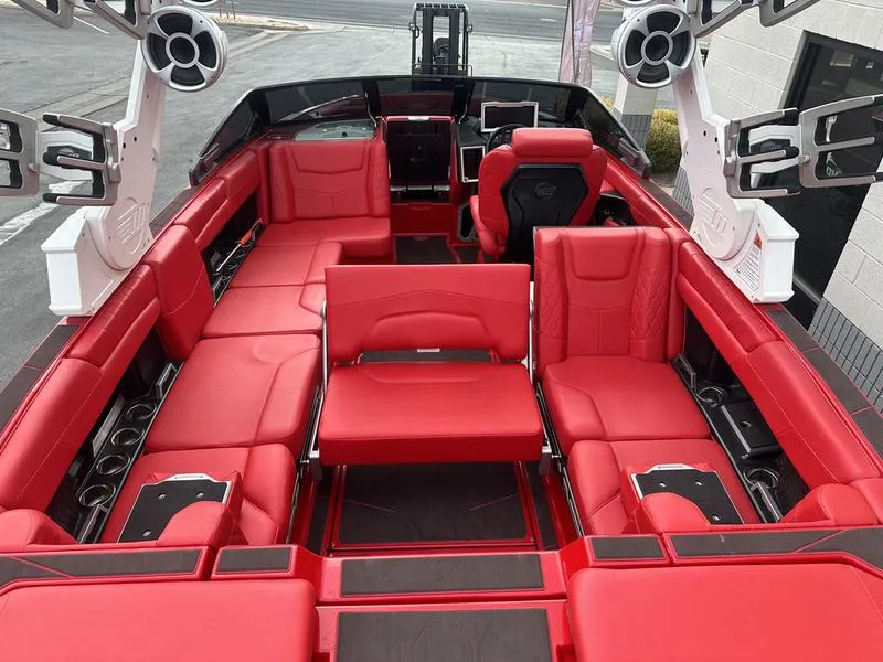 Slide: The Image of 2021 Malibu M240 boat interior with luxurious red seating and advanced audio system. - 23