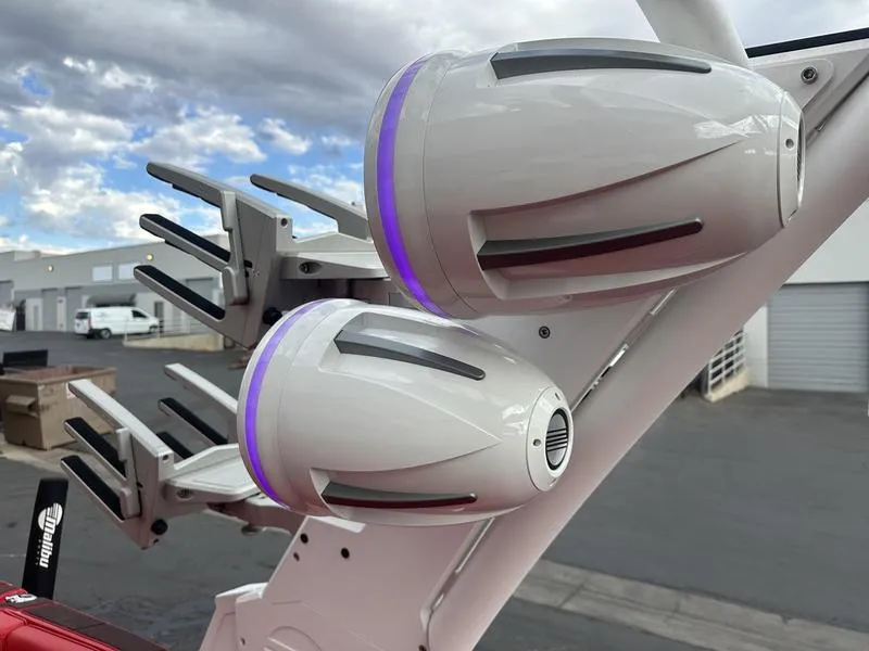 Slide: The Image of Malibu M240 2021 boat speakers and wakeboard racks under cloudy sky. - 4