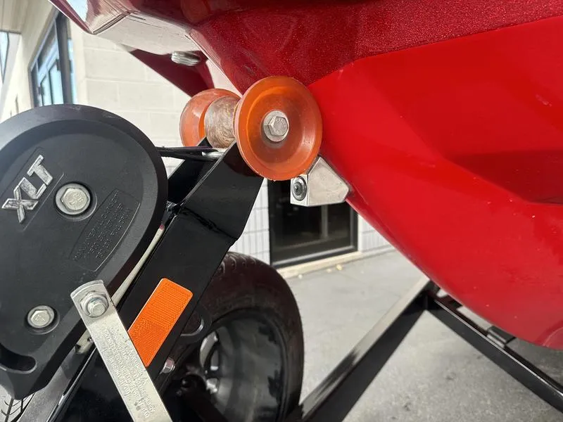 Slide: The Image of Close-up of 2021 Malibu M240 boat trailer with red hull and XLT winch. - 8