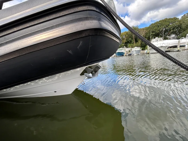 Slide: The Image of 2025 Grand Inflatables G850 boat docked on calm water, under a partly cloudy sky. - 11
