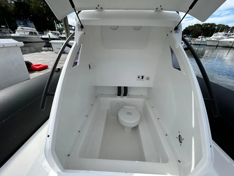 Slide: The Image of 2025 Grand Inflatables G850 boat interior with open hatch and visible toilet. - 27