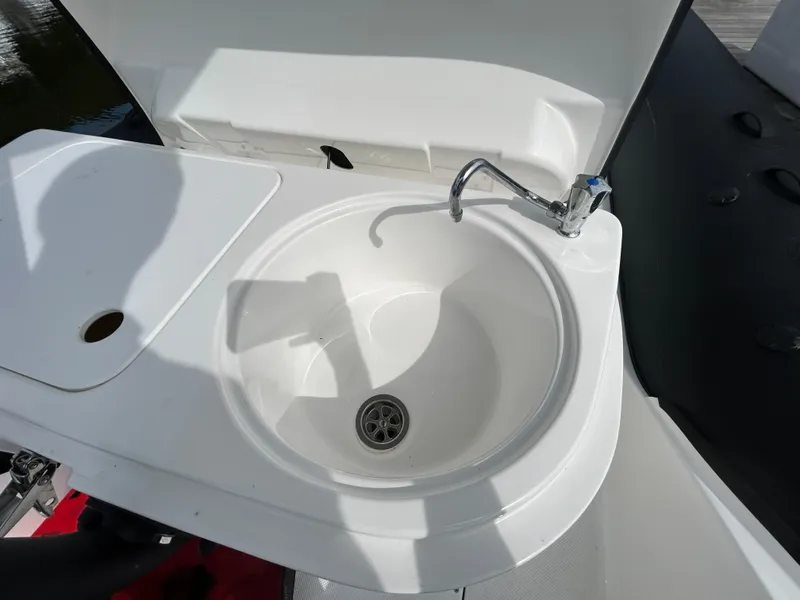 Slide: The Image of 2025 Grand Inflatables G850 boat sink with faucet, white basin, and countertop. - 29