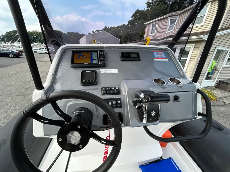 Slide: The Image of 2025 Grand Inflatables G850 boat dashboard with steering wheel and navigation controls. - 33