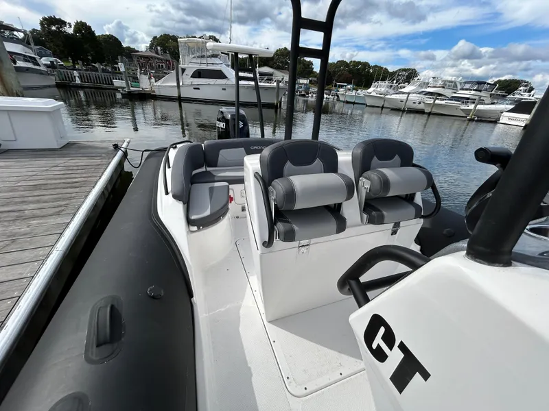 Slide: The Image of 2025 Grand Inflatables G850 boat docked at marina, featuring sleek seating and modern design. - 21