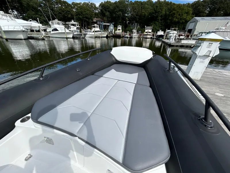 Slide: The Image of 2025 Grand Inflatables G850 boat with sleek seating at a marina. - 23