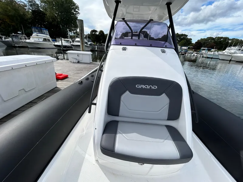 Slide: The Image of 2025 Grand Inflatables G850 boat at marina, featuring sleek seating and modern design. - 24