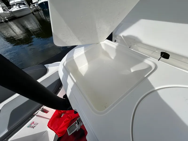 Slide: The Image of Open storage compartment on 2025 Grand Inflatables G850 boat, docked by the water. - 30