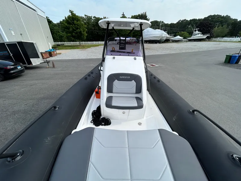 Slide: The Image of 2025 Grand Inflatables G850 boat with sleek seating, docked outdoors. - 36