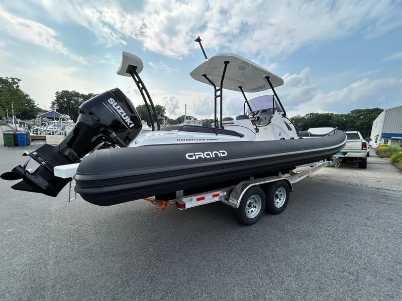 Slide: The Image of 2025 Grand Inflatables G850 boat on trailer, featuring Suzuki outboard motor. - 9