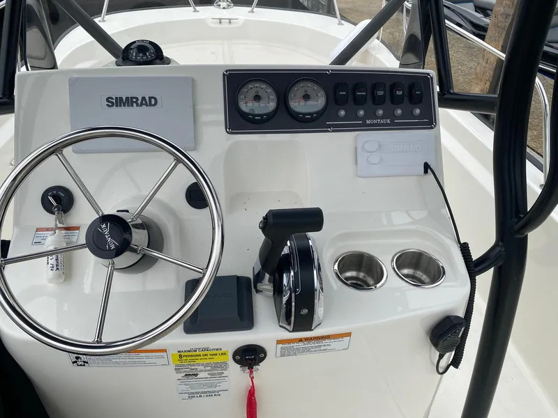 Slide: The Image of 2023 Boston Whaler 190 Montauk boat console with steering wheel and controls. - 12