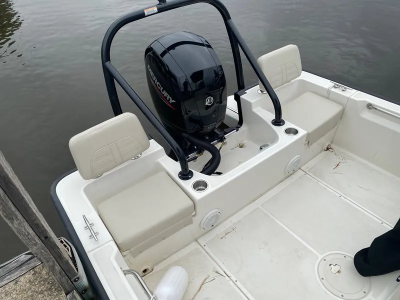 Slide: The Image of 2023 Boston Whaler 190 Montauk boat interior with Mercury engine, docked on calm water. - 16
