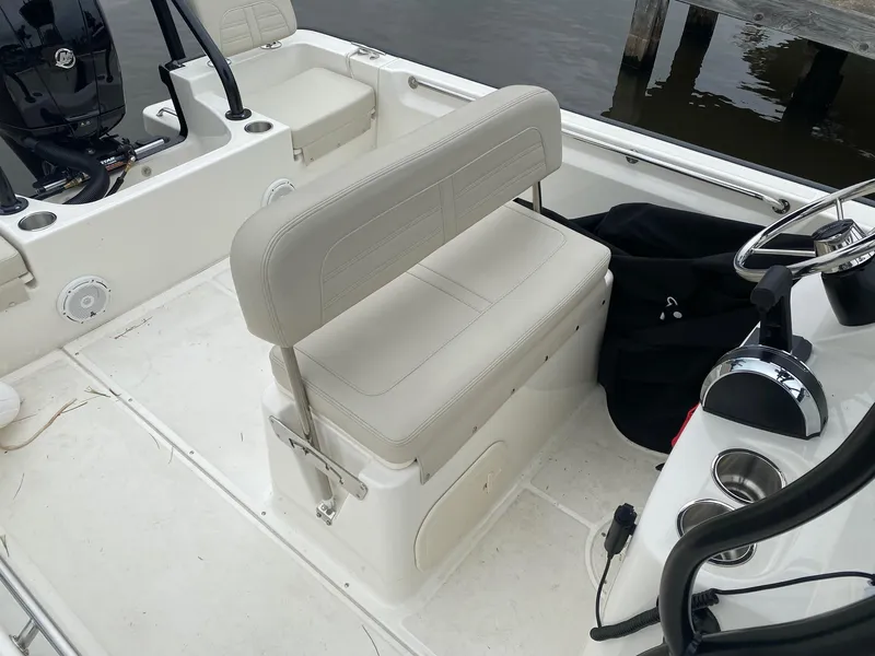 Slide: The Image of 2023 Boston Whaler 190 Montauk boat interior with beige seating and steering console. - 17