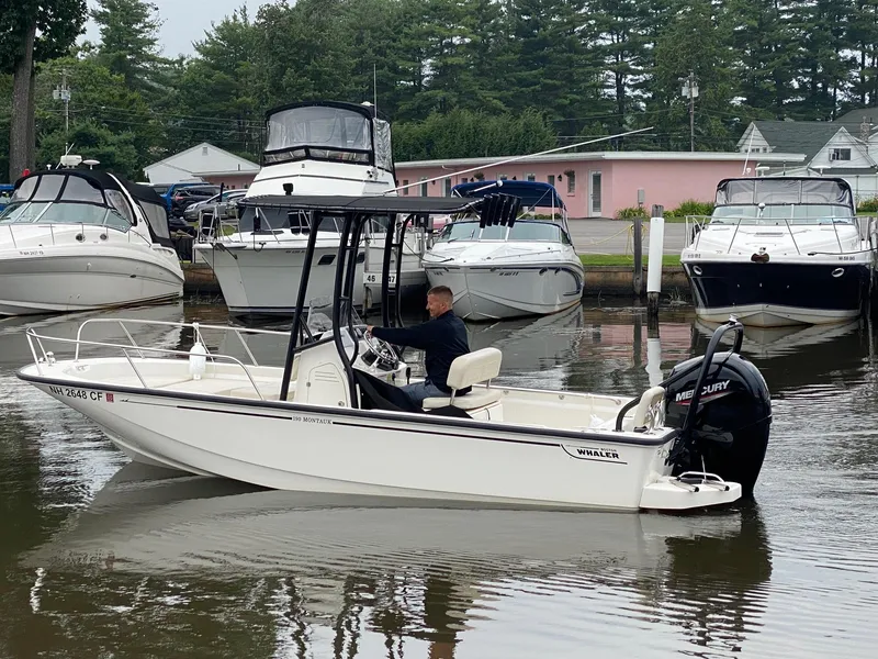 Slide: The Image of 2023 Boston Whaler 190 Montauk boat docked in marina with other vessels. - 2