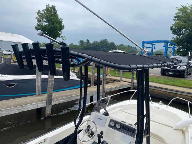 Slide: The Image of 2023 Boston Whaler 190 Montauk boat with T-top and rod holders at a marina. - 8