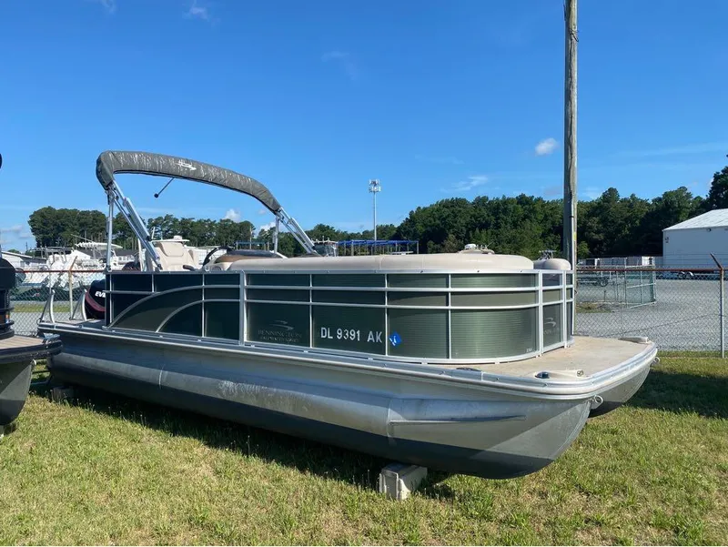 Slide: The Image of 2017 Bennington 22 SLX pontoon boat on grass, sunny day, blue sky background. - 1