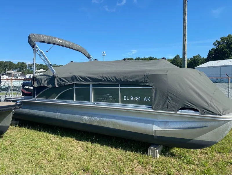 Slide: The Image of 2017 Bennington 22 SLX pontoon boat covered, parked on grass. - 8