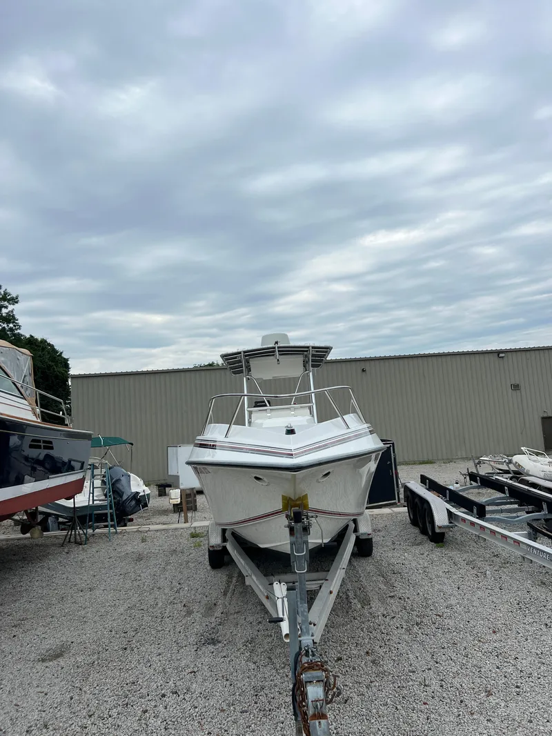 Slide: The Image of 1998 Fountain 31 CC boat on trailer, parked outdoors under cloudy sky. - 2