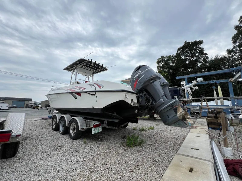Slide: The Image of 1998 Fountain 31 CC boat with Yamaha outboard motor on a trailer, parked outdoors. - 4