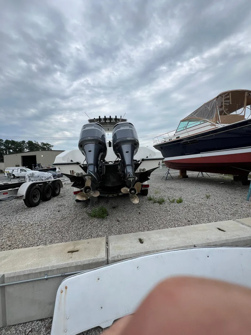 Slide: The Image of 1998 Fountain 31 CC boat with dual outboard motors on gravel lot. - 5
