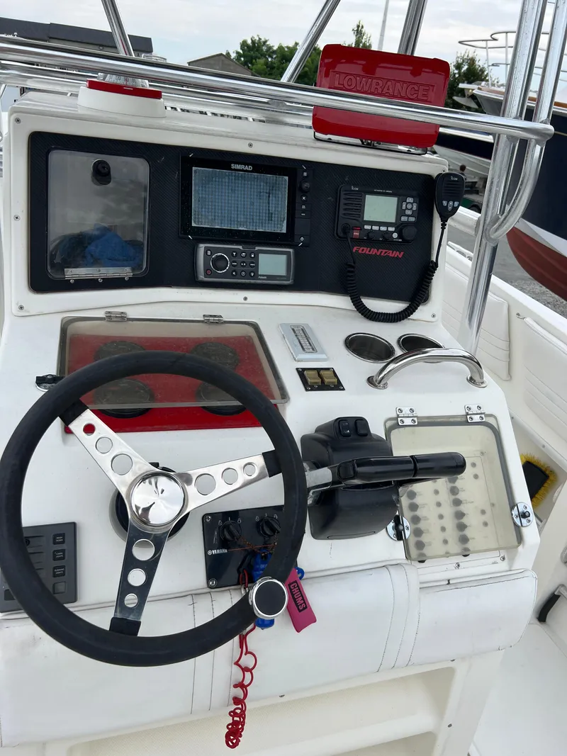 Slide: The Image of 1998 Fountain 31 CC boat dashboard with steering wheel and navigation equipment. - 8