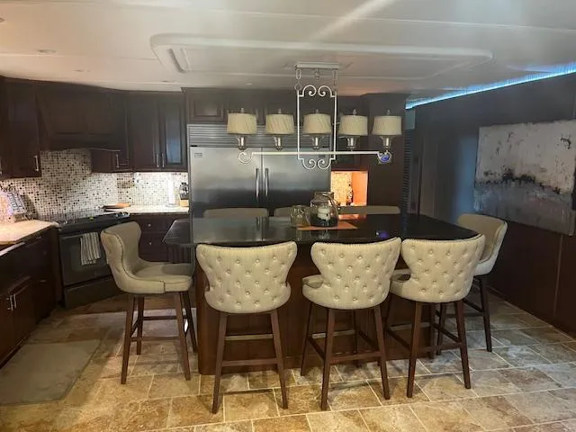 Slide: The Image of Luxurious 2010 Stardust Cruisers houseboat kitchen with island, bar stools, and modern decor. - 18