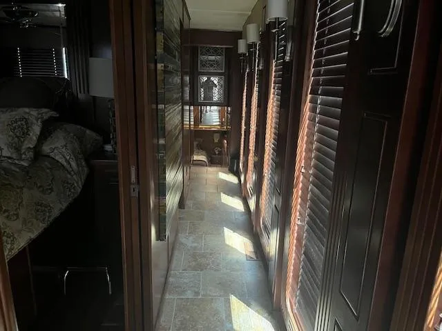 Slide: The Image of Narrow hallway inside 2010 Stardust Cruisers houseboat with wooden paneling and natural light. - 20