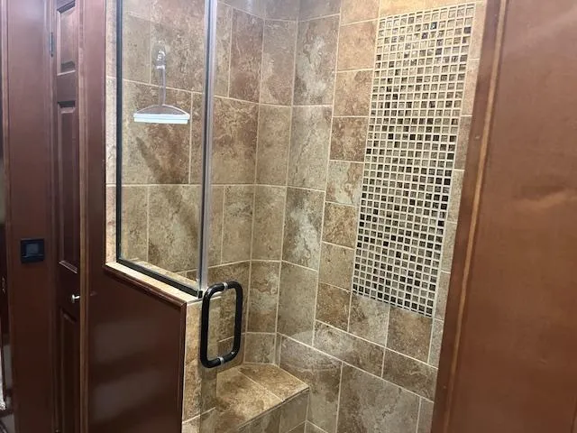 Slide: The Image of Luxurious tiled shower in 2010 Stardust Cruisers houseboat, featuring glass door and built-in seat. - 38