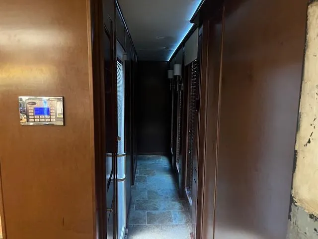 Slide: The Image of Narrow hallway inside 2010 Stardust Cruisers houseboat with wood paneling and tiled floor. - 40