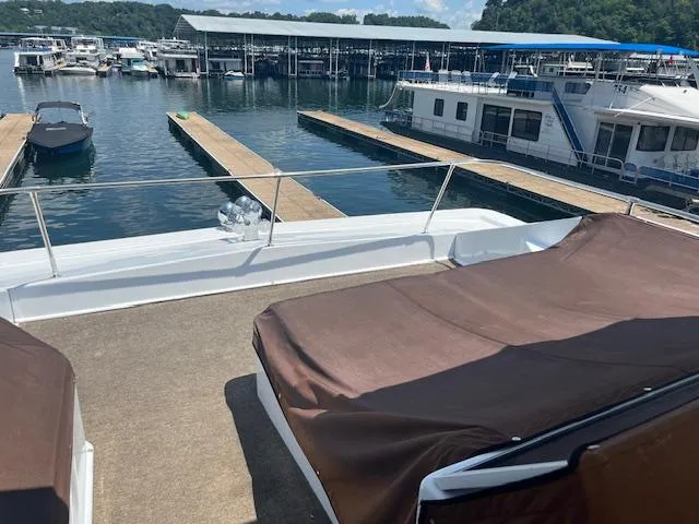 Slide: The Image of 2010 Stardust Cruisers houseboat docked at marina with covered seating area. - 45