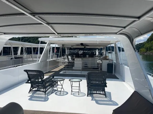 Slide: The Image of 2010 Stardust Cruisers houseboat deck with seating, tables, and canopy on a sunny day. - 46